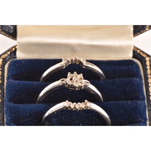 28 - A set of three 9ct white gold and diamond rings, to include a floral ring set with seven round brill... 