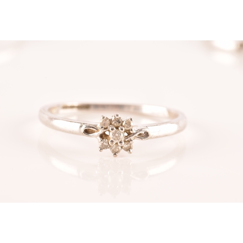 28 - A set of three 9ct white gold and diamond rings, to include a floral ring set with seven round brill... 