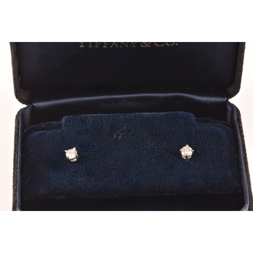 30 - Tiffany & Co. A pair of platinum set, round brilliant cut diamond studs, with a combined diamond... 