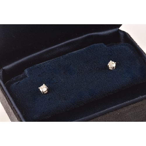 30 - Tiffany & Co. A pair of platinum set, round brilliant cut diamond studs, with a combined diamond... 