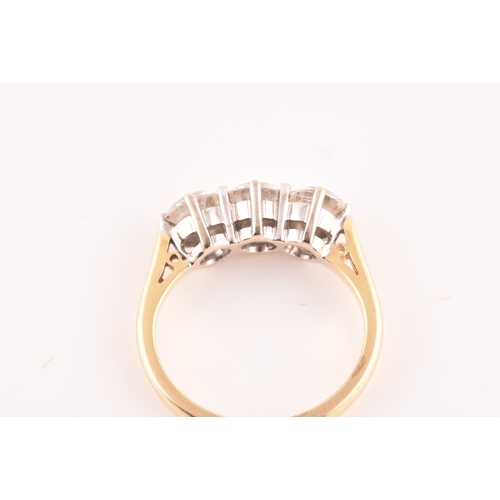 11 - A three stone 18ct yellow and white metal diamond ring, set with three round brilliant cut diamonds ... 