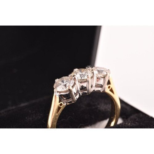 11 - A three stone 18ct yellow and white metal diamond ring, set with three round brilliant cut diamonds ... 