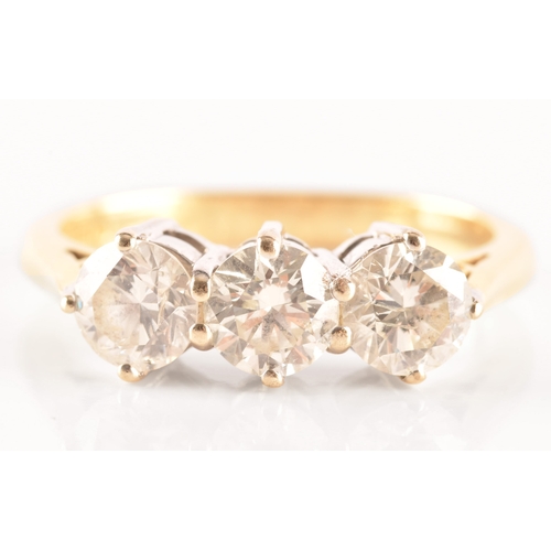 11 - A three stone 18ct yellow and white metal diamond ring, set with three round brilliant cut diamonds ... 