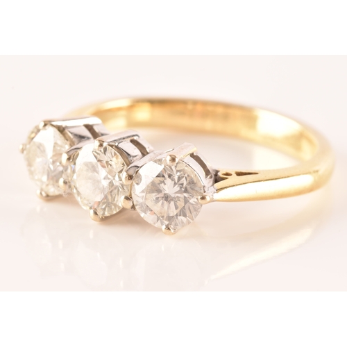 11 - A three stone 18ct yellow and white metal diamond ring, set with three round brilliant cut diamonds ... 