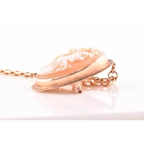 32 - A Cameo rose metal pendant/brooch on a 9ct gold chain, pendant length 3.5cm, chain length 60 cm.