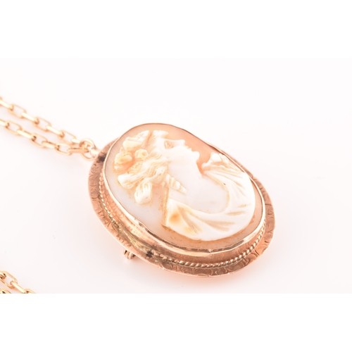 32 - A Cameo rose metal pendant/brooch on a 9ct gold chain, pendant length 3.5cm, chain length 60 cm.