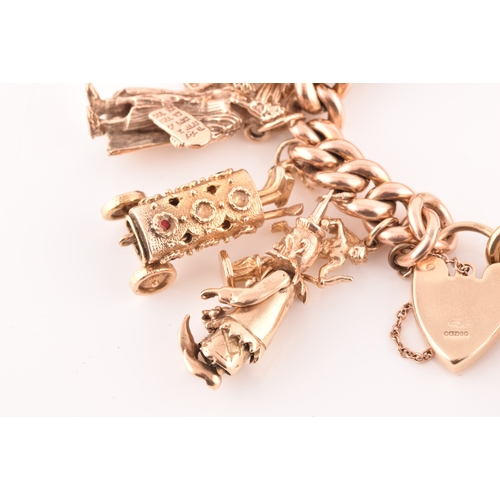 1 - A 9ct rose gold curb link charm bracelet, suspended with a vast collection of 9ct yellow gold charms... 