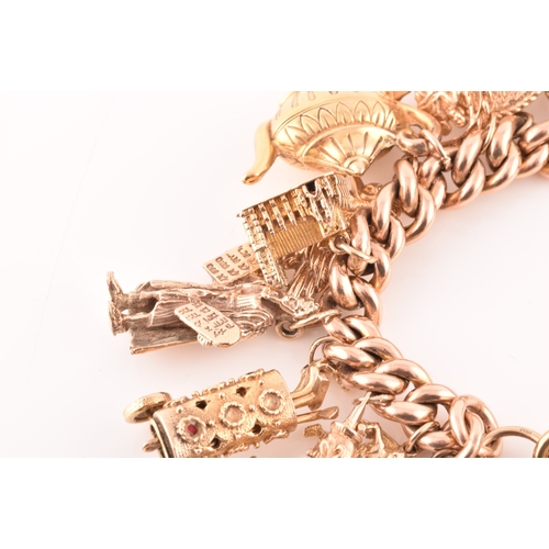 1 - A 9ct rose gold curb link charm bracelet, suspended with a vast collection of 9ct yellow gold charms... 