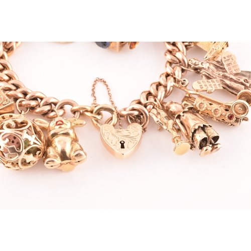 1 - A 9ct rose gold curb link charm bracelet, suspended with a vast collection of 9ct yellow gold charms... 