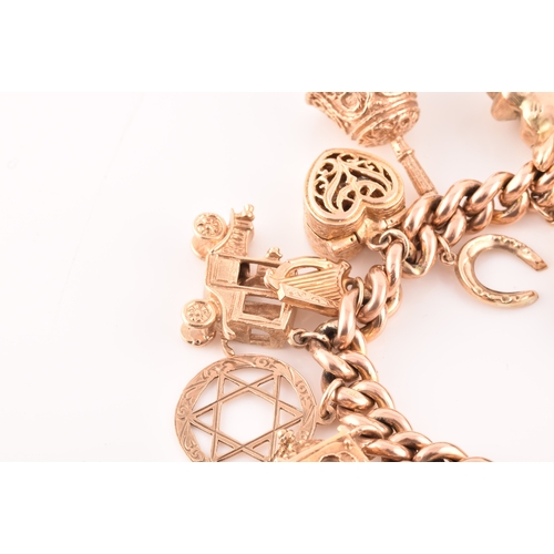 1 - A 9ct rose gold curb link charm bracelet, suspended with a vast collection of 9ct yellow gold charms... 