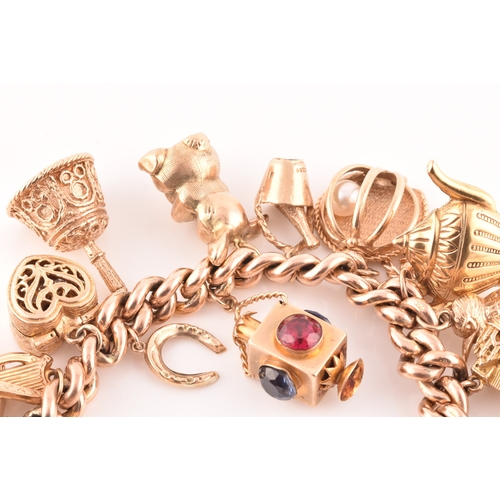 1 - A 9ct rose gold curb link charm bracelet, suspended with a vast collection of 9ct yellow gold charms... 