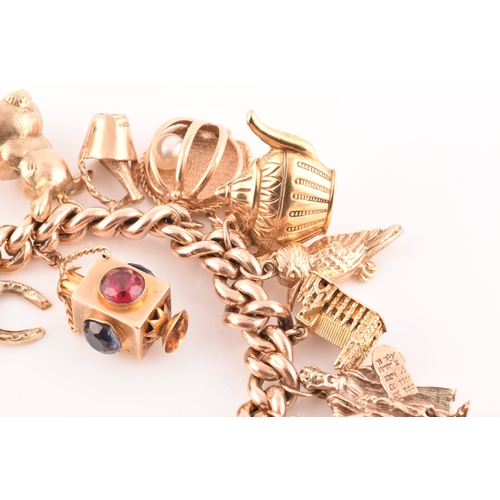 1 - A 9ct rose gold curb link charm bracelet, suspended with a vast collection of 9ct yellow gold charms... 