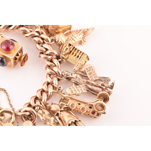 1 - A 9ct rose gold curb link charm bracelet, suspended with a vast collection of 9ct yellow gold charms... 