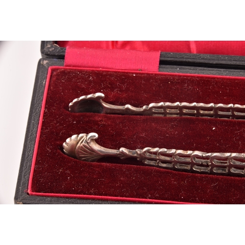 135 - A pair of Georgian cast silver sugar tongs, by Richard Mills, crest engraved, featuring floral  deco... 