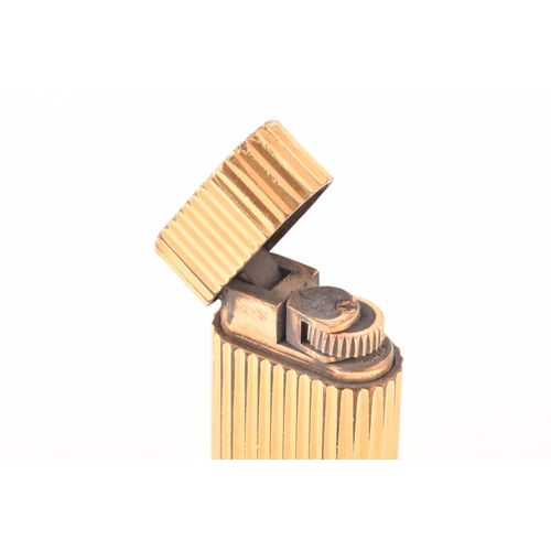 89 - A Cartier gold plated ribbed cigarette lighter, signed Cartier and numbered A44844 to the base, toge... 