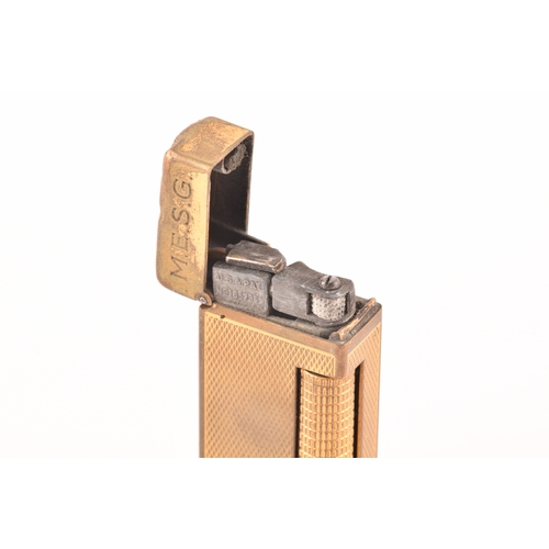 89 - A Cartier gold plated ribbed cigarette lighter, signed Cartier and numbered A44844 to the base, toge... 