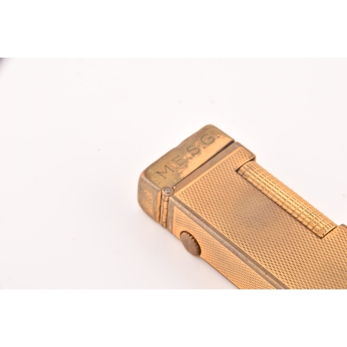 89 - A Cartier gold plated ribbed cigarette lighter, signed Cartier and numbered A44844 to the base, toge... 