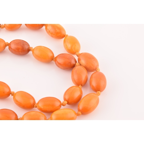 39 - A single row graduated oval amber bead necklace, approximately 12 x 7.5mm to 30 x 20 mm, strung plai... 