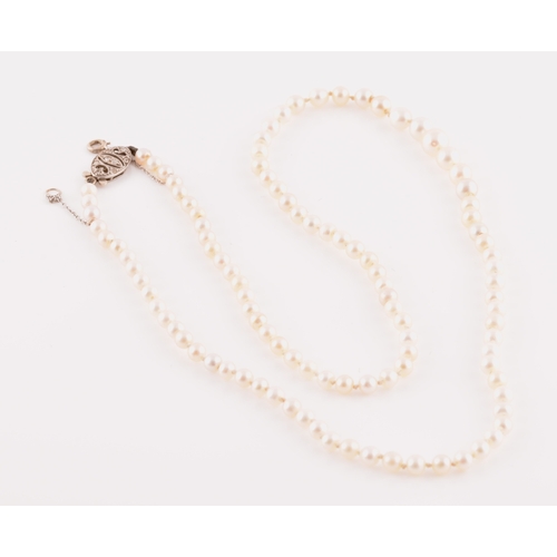 41 - A graduated pearl necklace, pearls measuring 3.4mm to 6.0mm, the white metal clasp set with old cut ... 