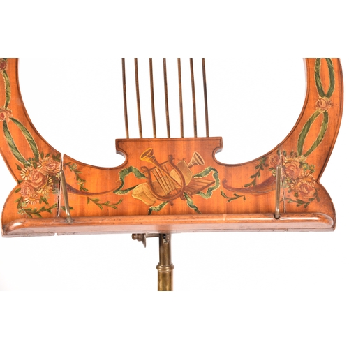 302 - An Edwardian Sheraton revival painted satinwood adjustable music stand, painted with musical instrum... 