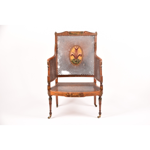 303 - An Edwardian Sheraton revival bergere armchair, the top rail painted with a scene of children playin... 