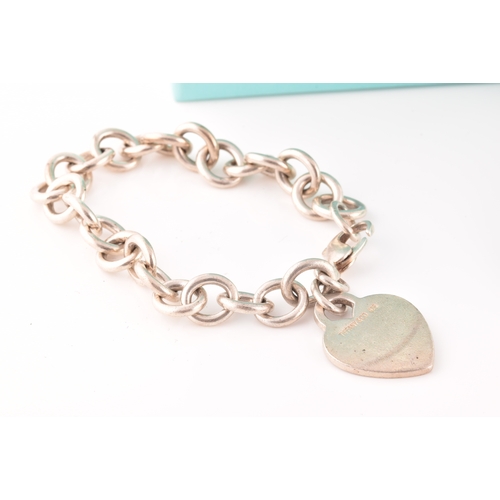 49 - A Tiffany & Co silver bracelet with heart charm, length 18 cm, in original pouch and box, togeth... 