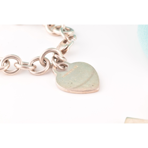 49 - A Tiffany & Co silver bracelet with heart charm, length 18 cm, in original pouch and box, togeth... 