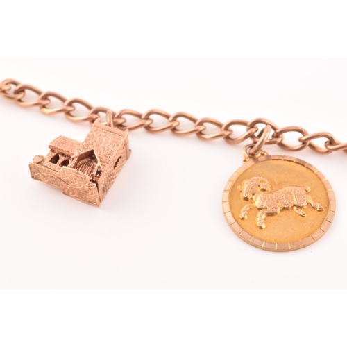 52 - A 9ct rose gold charm bracelet, suspended with three 9ct yellow gold charms, two rose metal charms, ... 