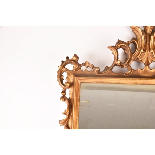 307 - A Rococo style gilt gesso wall mirror, with elaborate scrolled frame and rectangular plate, 79.5 x 5... 