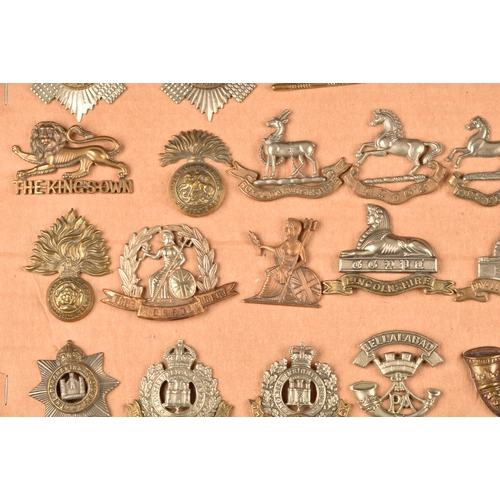 481 - A collection of military cap badges, including The Royal Scots Regiment, The Buffs, The Norfolk Regi... 