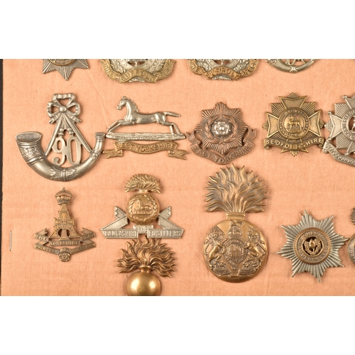 481 - A collection of military cap badges, including The Royal Scots Regiment, The Buffs, The Norfolk Regi... 