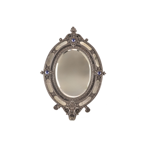 284 - A Victorian metal oval easel mirror, the elaborate frame with scrolled and engraved decoration, with... 