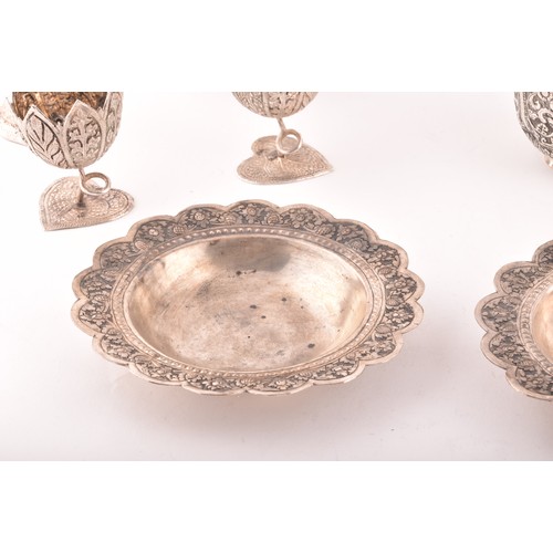 158 - A collection of Burmese white metal objects, including three dishes, a pair of spill vases, a pair o... 