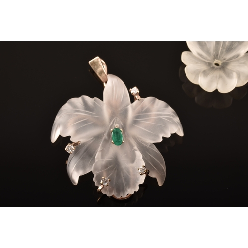 97 - A yellow metal rock crystal flower pendant, featuring an oval cut emerald to centre with an approxim... 