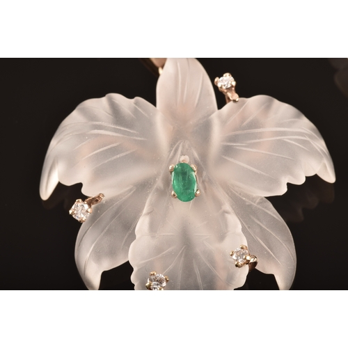 97 - A yellow metal rock crystal flower pendant, featuring an oval cut emerald to centre with an approxim... 