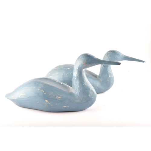 331 - A pair of blue painted carved wooden birds, possibly Grebes, in seated / swimming position.