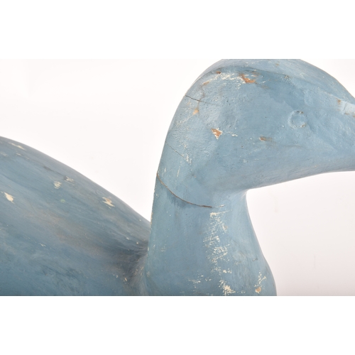 331 - A pair of blue painted carved wooden birds, possibly Grebes, in seated / swimming position.