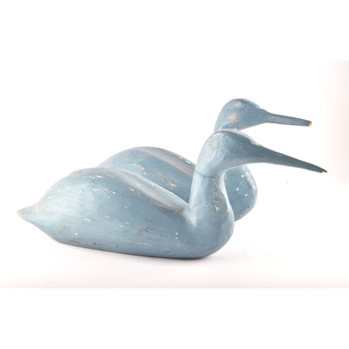 331 - A pair of blue painted carved wooden birds, possibly Grebes, in seated / swimming position.