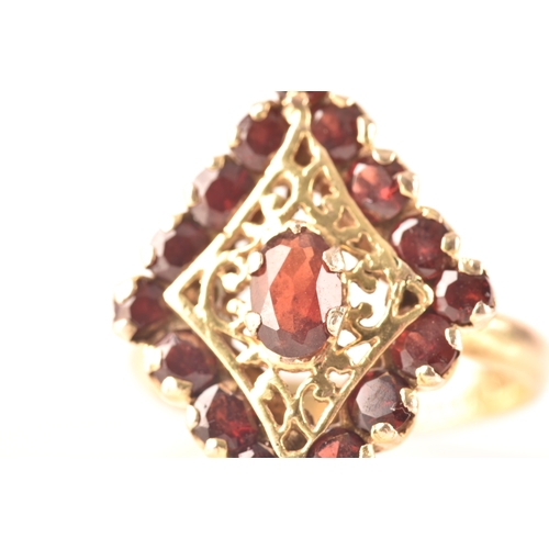 115 - A 9ct yellow gold marquise cluster ring, set to centre with a oval garnet, surrounded by round garne... 