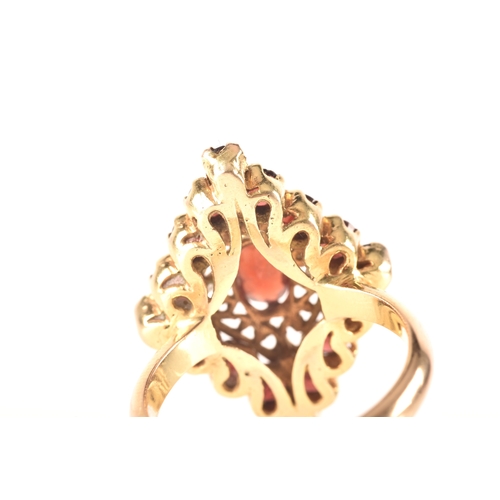 115 - A 9ct yellow gold marquise cluster ring, set to centre with a oval garnet, surrounded by round garne... 