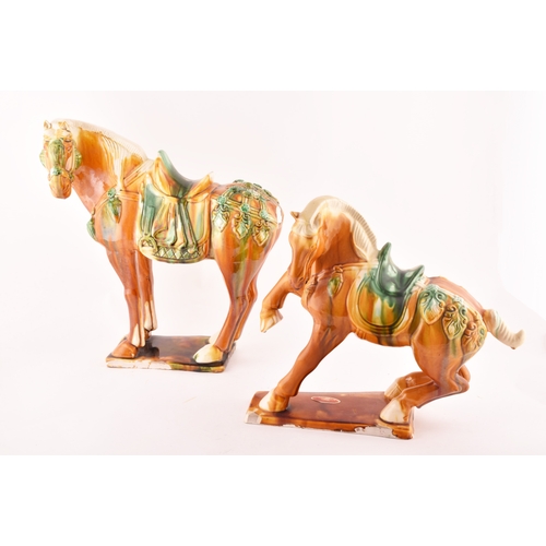 239 - A pair of Chinese Tang Dynasty Sancai style glazed ceramic war horses, 20 cm high.