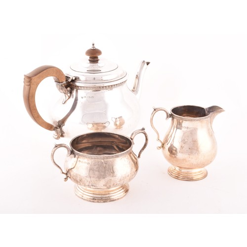 179 - A George V three piece silver tea set, comprising a silver teapot, 16cm high, a silver milk jug, 9cm... 