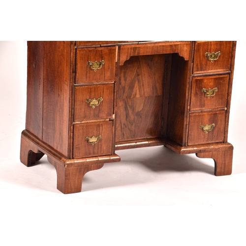 294 - An early 18th century walnut kneehole desk, the oyster veneered walnut cross banded top over a friez... 