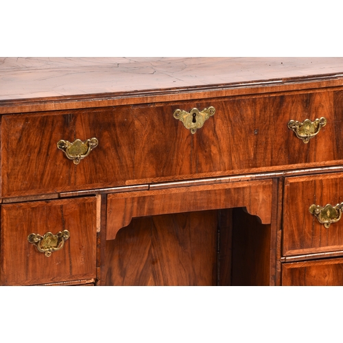 294 - An early 18th century walnut kneehole desk, the oyster veneered walnut cross banded top over a friez... 