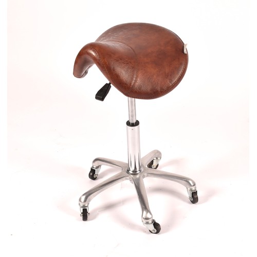 302 - A Nicholas tan leather barber chair, height adjustable, with reclining back and head rest, supported... 