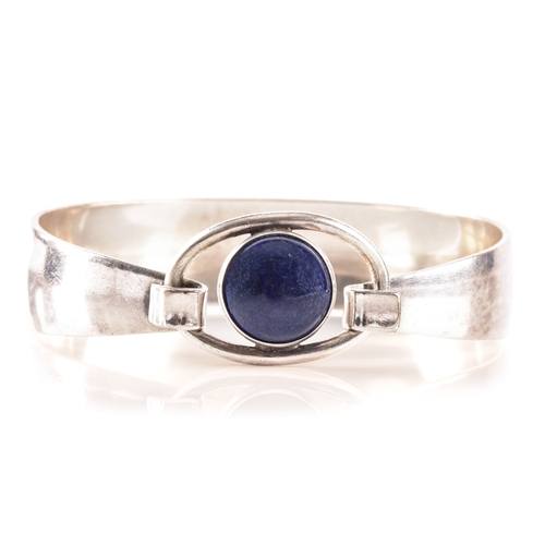 76 - A 1970's Danish sterling silver bangle set with a cabochon blue stone by Niels Erik, diameter 6cm.