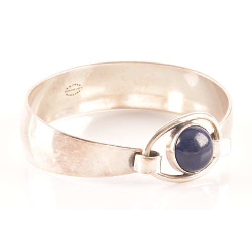 76 - A 1970's Danish sterling silver bangle set with a cabochon blue stone by Niels Erik, diameter 6cm.