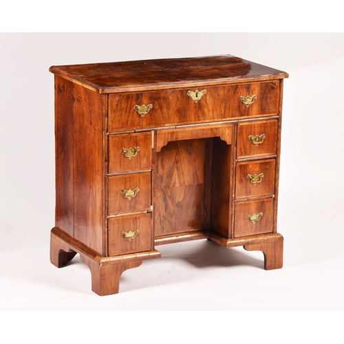 367 - An early 18th century walnut kneehole desk, the oyster veneered walnut cross banded top over a friez... 