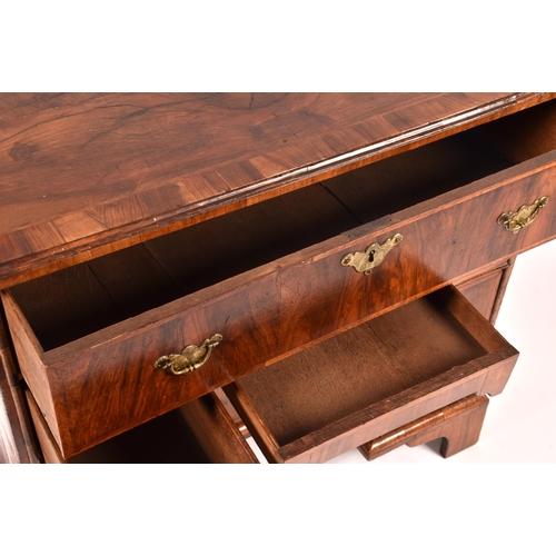 367 - An early 18th century walnut kneehole desk, the oyster veneered walnut cross banded top over a friez... 