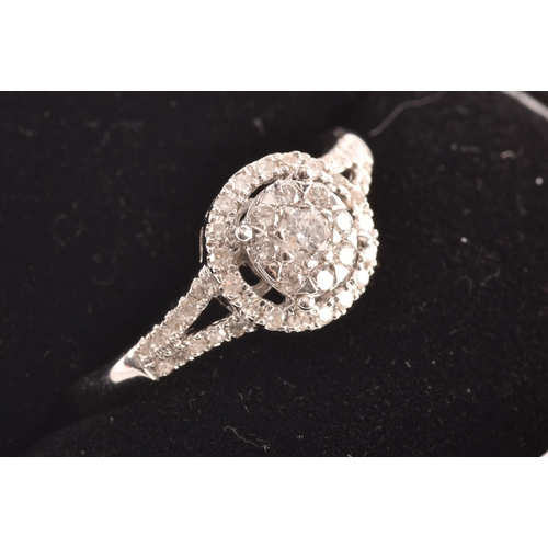 29 - An 18ct white gold diamond round cluster ring, set to centre with a cluster of brilliant cut diamond... 